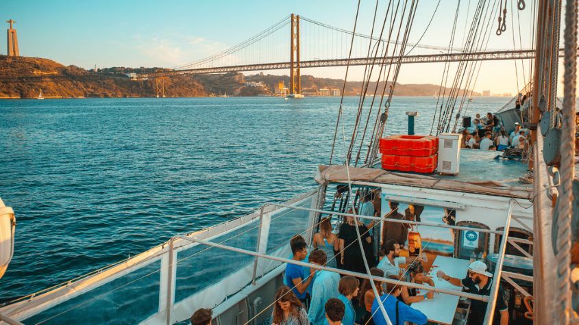 A team participating in a team-building activity aboard a boat on the Tagus River