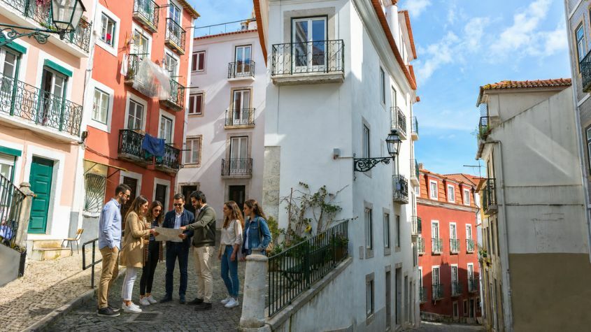 A group of friends on a team-building outing through the Alfama neighborhood in Lisbon