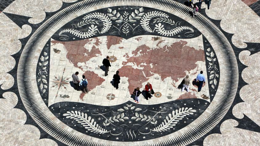 People admiring drawings on the floor depicting the Age of Discovery in Belém